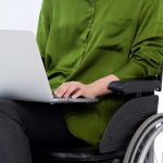 Ilustrasi Perempuan Disabilitas sedang Bekerja Menggunakan Gawai Laptop