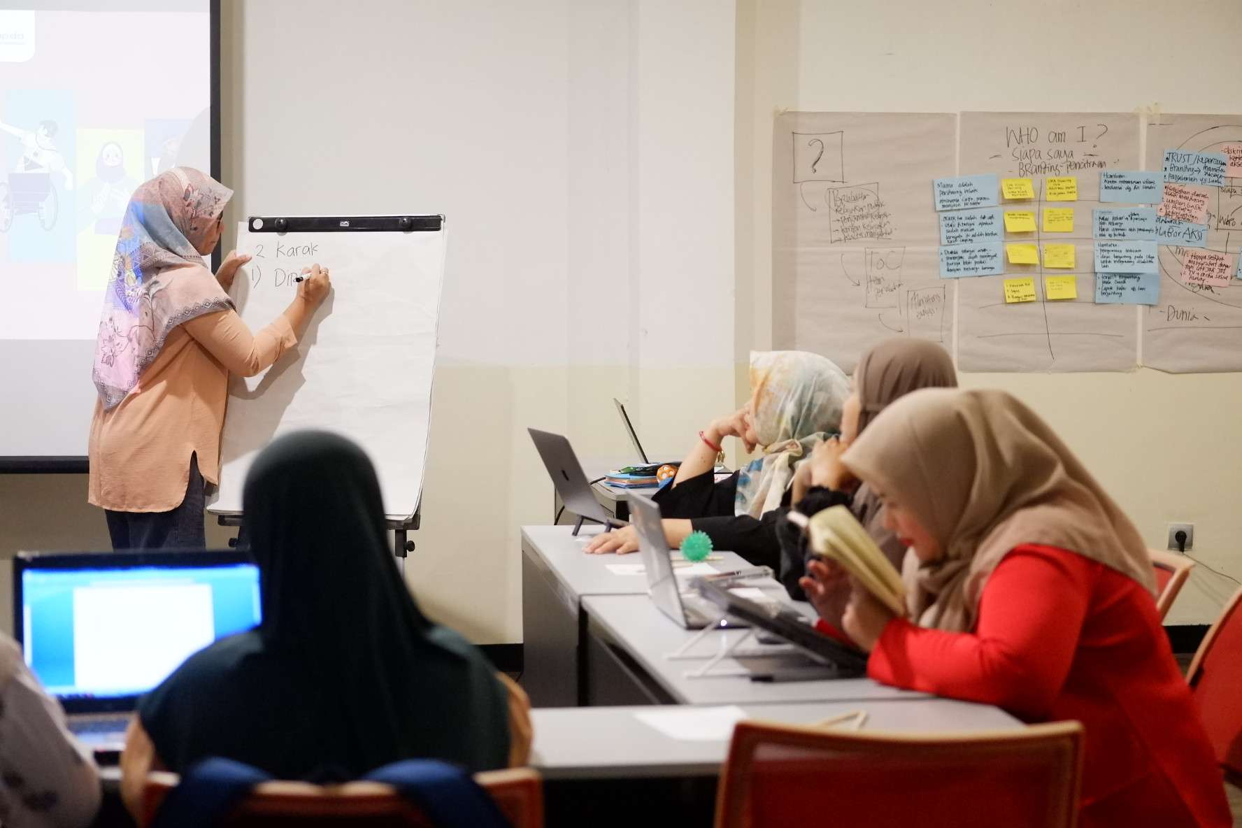 Foto menunjukkan kegiatan pelatihan feminisme disabilitas. Terdapat narasumber sedang menjelaskan di papan dan dilihat oleh peserta