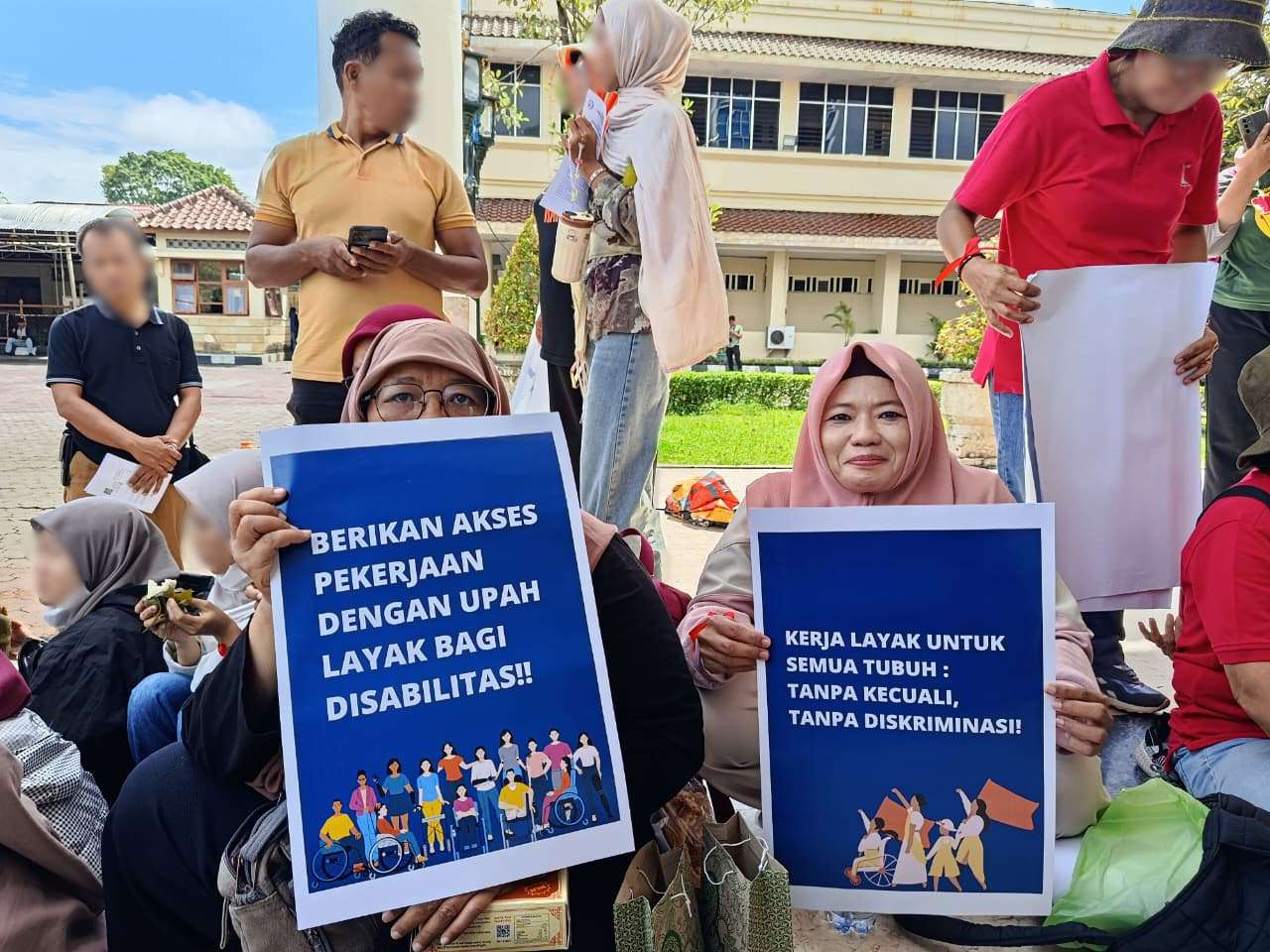 Dua perempuan disabilitas perwakilan dari SAPDA dalam kegiatan MayDay 2026 dengan membawa poster terkait peningkatan upah layaj bagi disabilitas